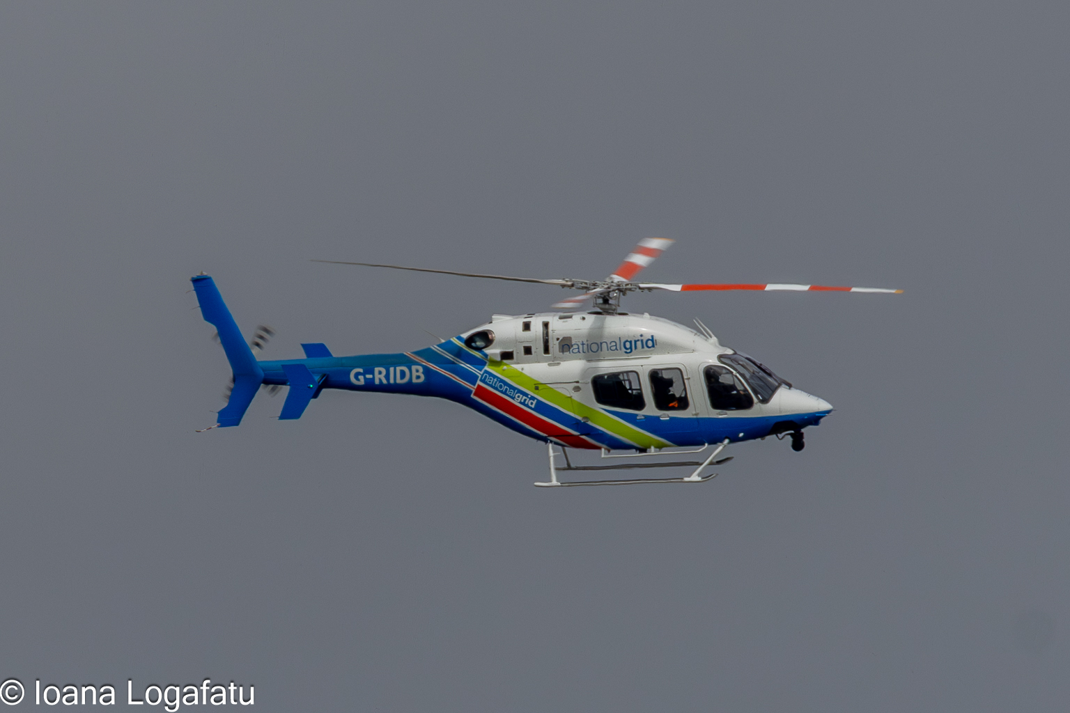 Helicopter gliding through a cloudy sky at dusk